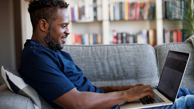 a man using a laptop on a sofa
