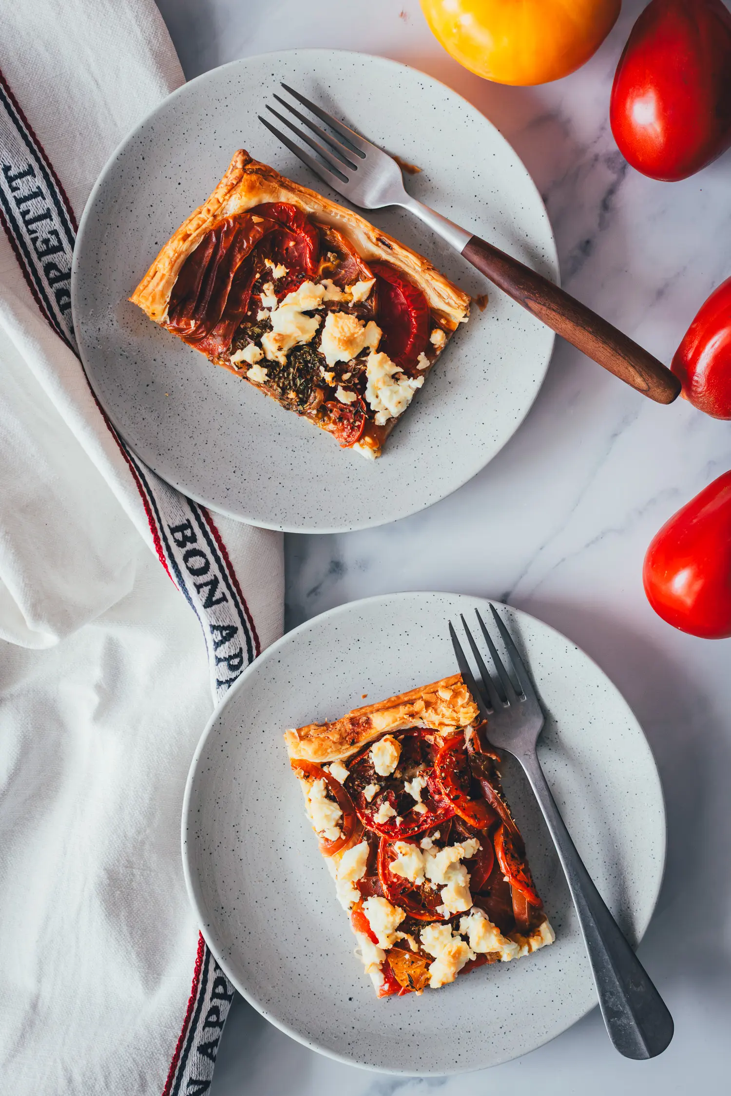 Topshot Aufnahme von zwei Tellern mit frisch gebackener Tomatenquiche.