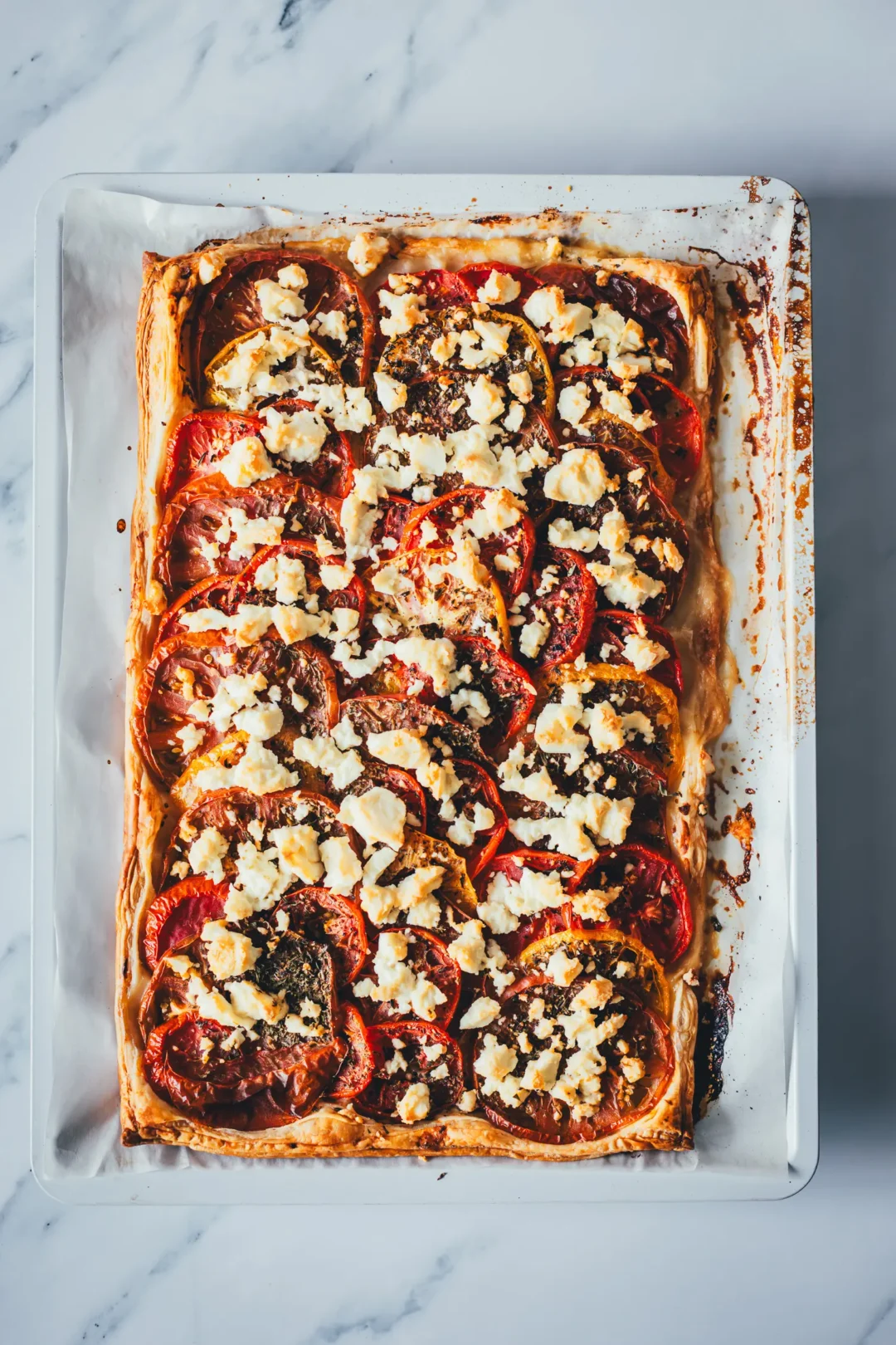 Als Topshot fotografierte, frisch gebackene Tomatenquiche auf dem Blech.