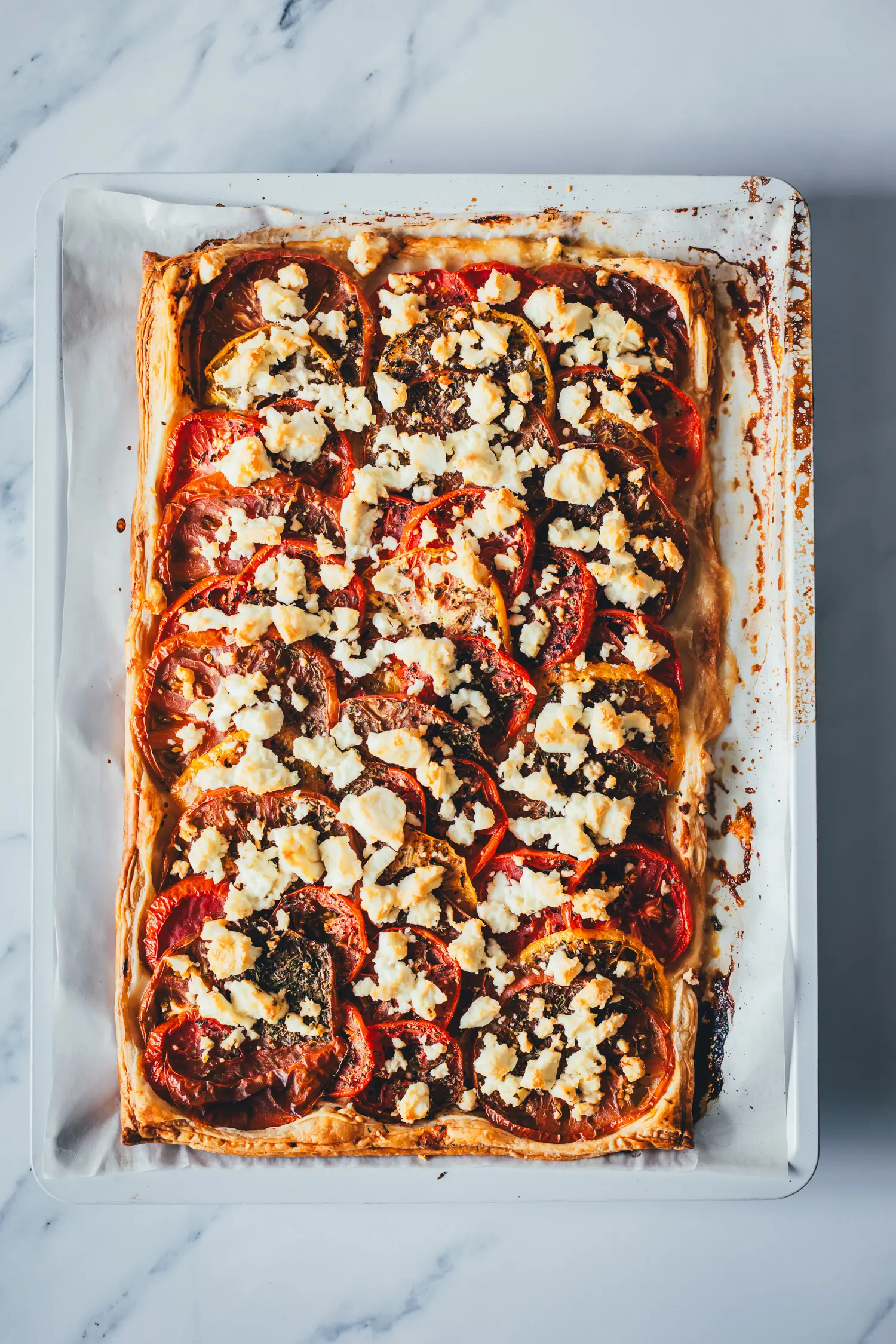 Als Topshot fotografierte, frisch gebackene Tomatenquiche auf dem Blech.