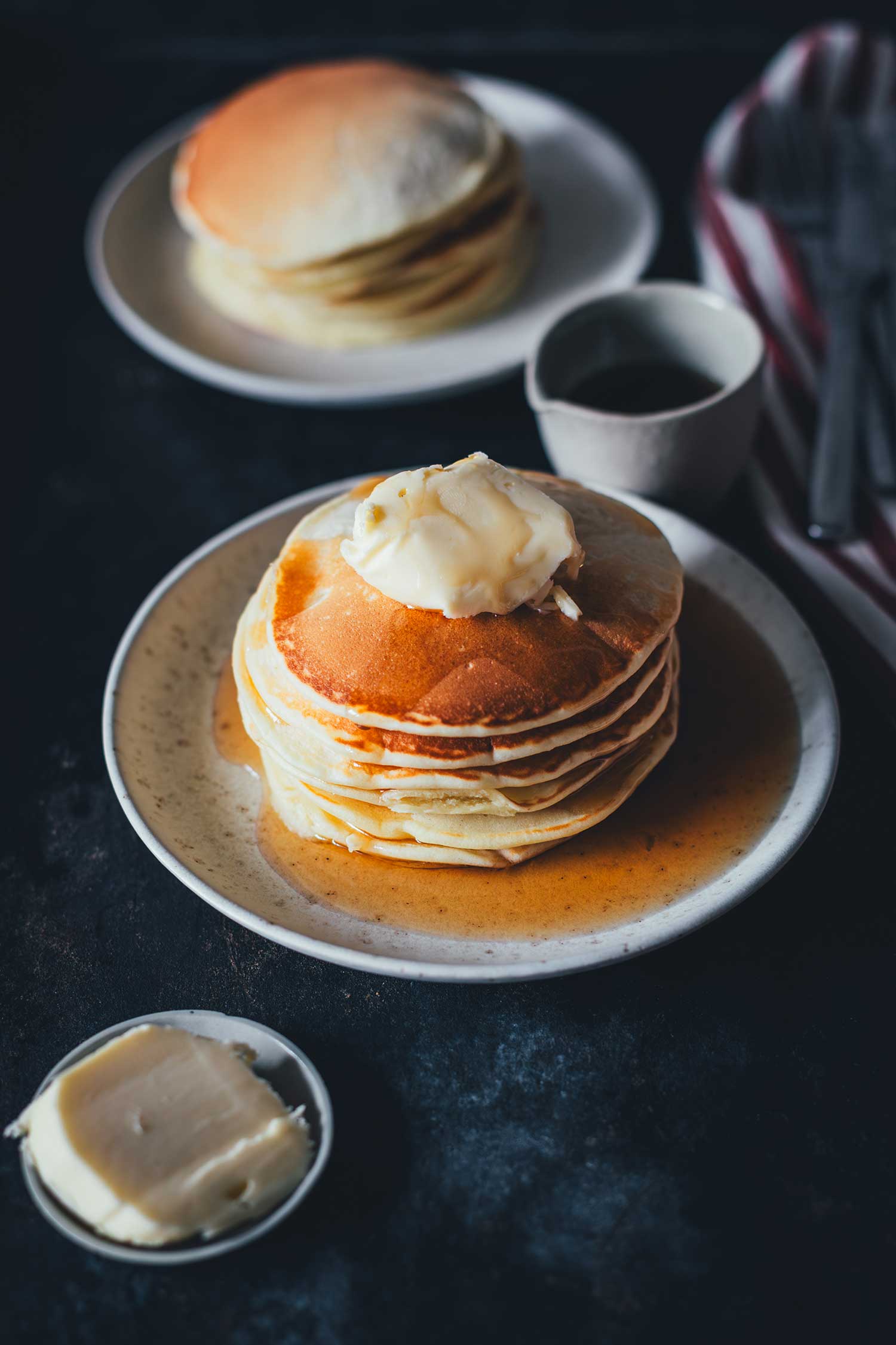 Pancakes mit Ahornsirup und Butter auf einem Teller serviert | moeyskitchen.com