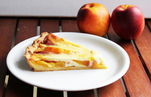 ein Stück frisch gebackene Tarte mit Nektarinen und Vanillecreme