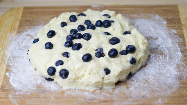 Rezept für Blueberry-Cream-Scones mit Clotted Cream und Marmelade zum Sonntagsfrühstück Teig für Scones mit Blaubeeren und Sahne wird in Form gebracht