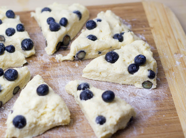 Rezept für Blueberry-Cream-Scones mit Clotted Cream und Marmelade zum Sonntagsfrühstück Der Teig für die Scones mit Blaubeeren und Sahne wird in Tortenstücke geteilt