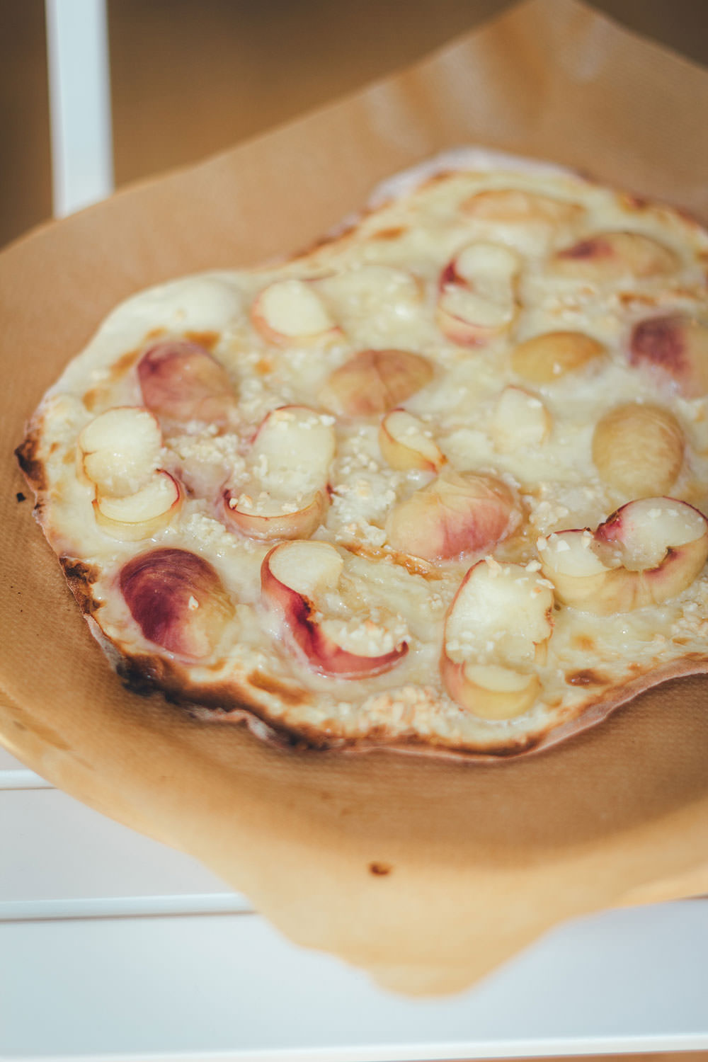 Rezept für sommerlichen Pfirsich-Flammkuchen mit Weinbergpfirsichen, Crème fraîche und Mandeln | moeyskitchen.com #flammkuchen #pfirsiche #weinbergpfirsich #mandeln #kuchenbacken #sommer #backen #rezepte #foodblogger