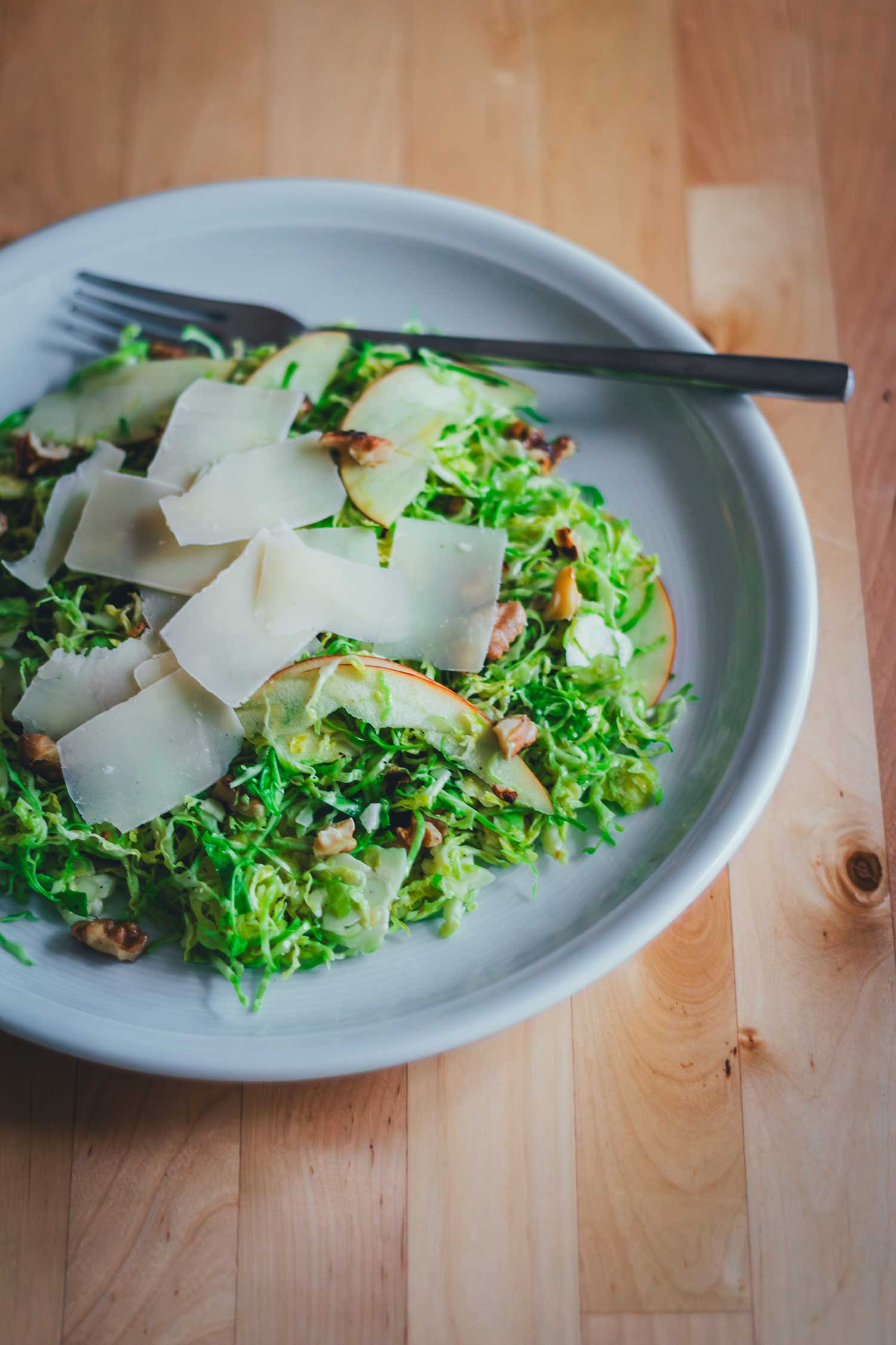 Rosenkohlsalat mit Apfel, Walnüssen und Pecorino – frischer Wintersalat auf einem Teller