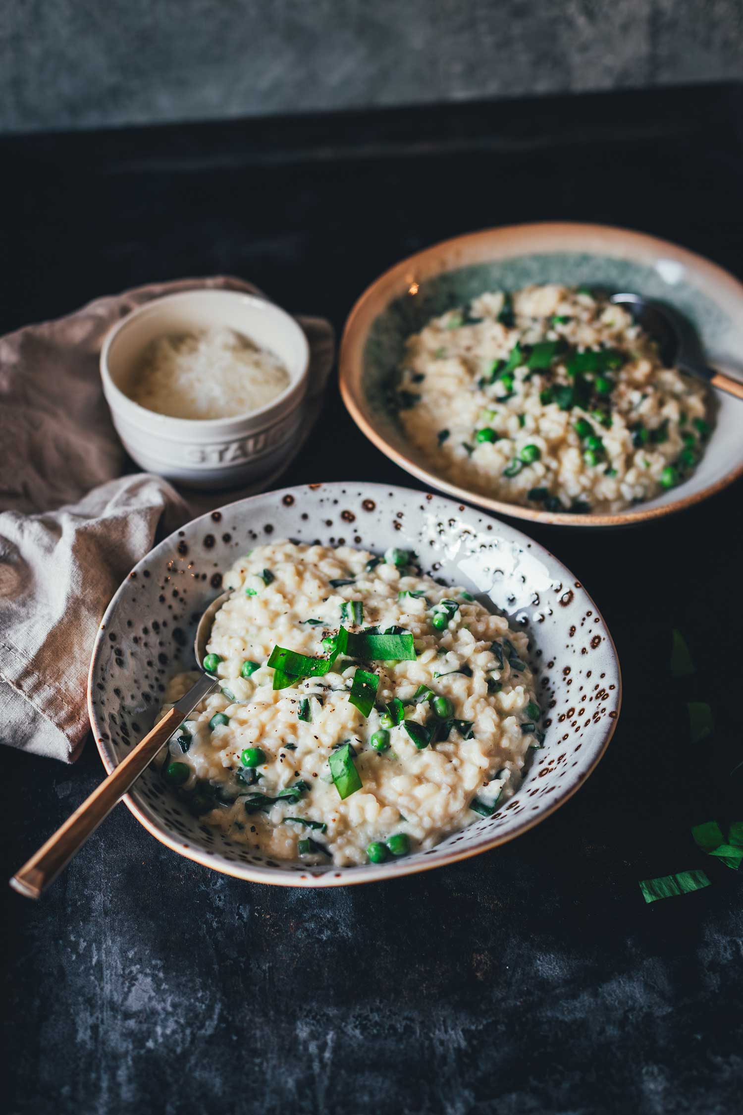 Seitliche Ansicht von zwei Tellern mit frisch serviertem Bärlauch Risotto.