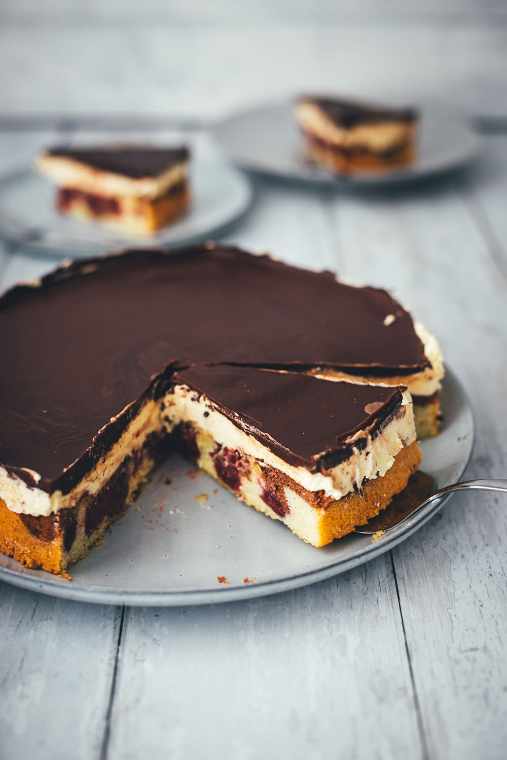 Hier gibt es das Rezept für eine leckere Donauwelle! Der Kuchenklassiker besteht aus einem hellen und dunklen Rührteig mit Schattenmorellen oder Kirschen, einer Pudding-Buttercreme und einer Schokoladen-Glasur. Der Kuchen benötigt etwas Ruhe- und Kühlzeit, ist aber super einfach zu backen! Ein absolutes Lieblingsrezept. | moeyskitchen.com