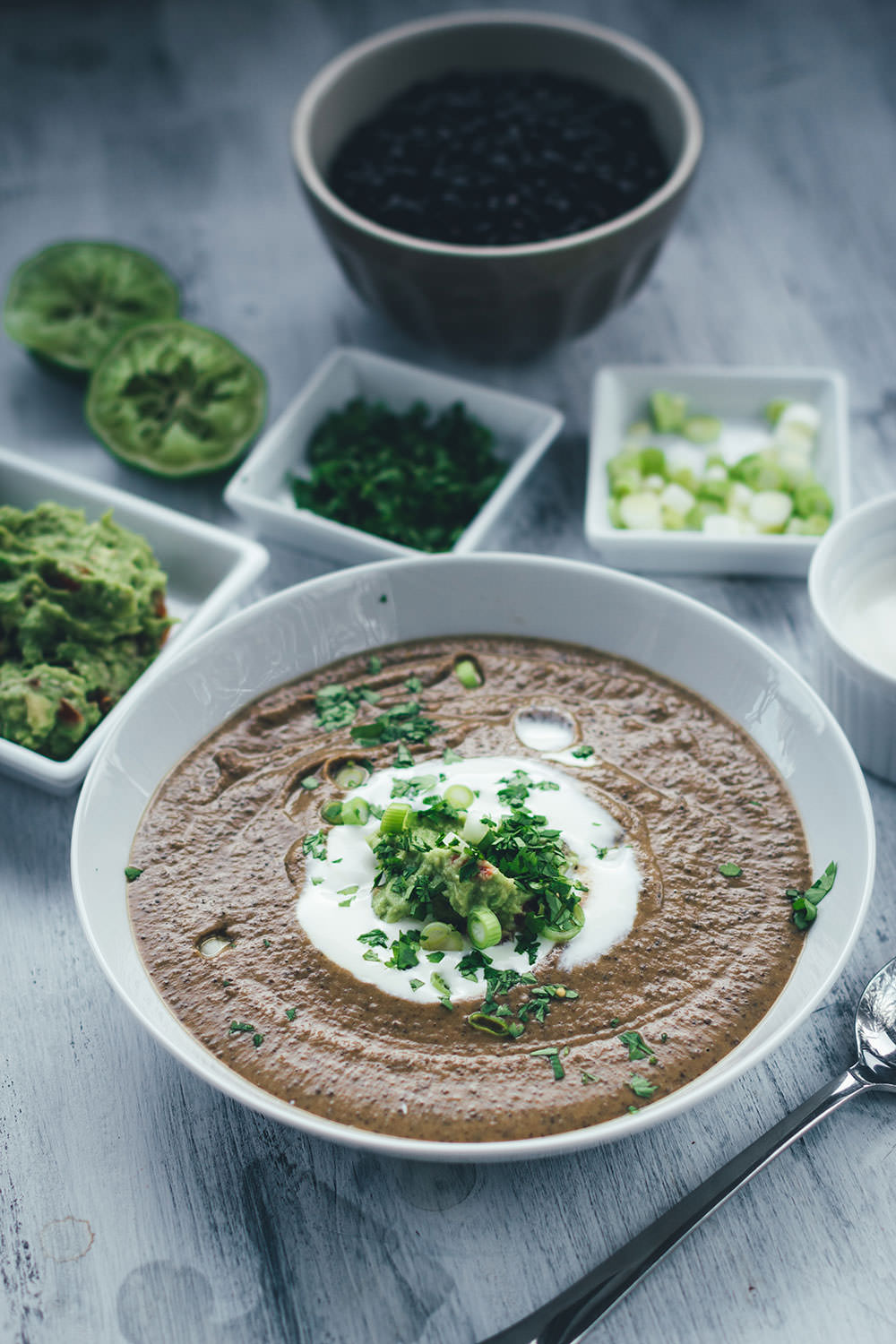 Rezept für vegetarische schwarze Bohnensuppe mit Guacamole, saurer Sahne, Limette und Koriander | moeyskitchen.com #rezepte #foodblogger #suppe #bohnen #schwarzebohnen #guacamole #vegetarischerezepte #vegetarischkochen #veggie