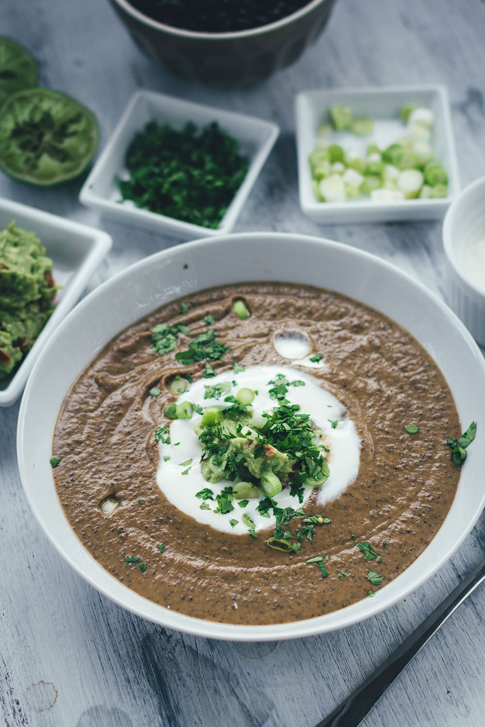 Rezept für vegetarische schwarze Bohnensuppe mit Guacamole, saurer Sahne, Limette und Koriander | moeyskitchen.com #rezepte #foodblogger #suppe #bohnen #schwarzebohnen #guacamole #vegetarischerezepte #vegetarischkochen #veggie