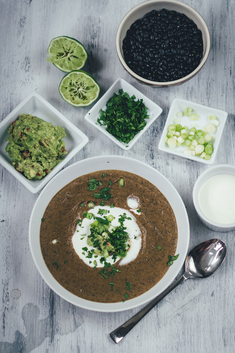 Rezept für vegetarische schwarze Bohnensuppe mit Guacamole, saurer Sahne, Limette und Koriander | moeyskitchen.com #rezepte #foodblogger #suppe #bohnen #schwarzebohnen #guacamole #vegetarischerezepte #vegetarischkochen #veggie