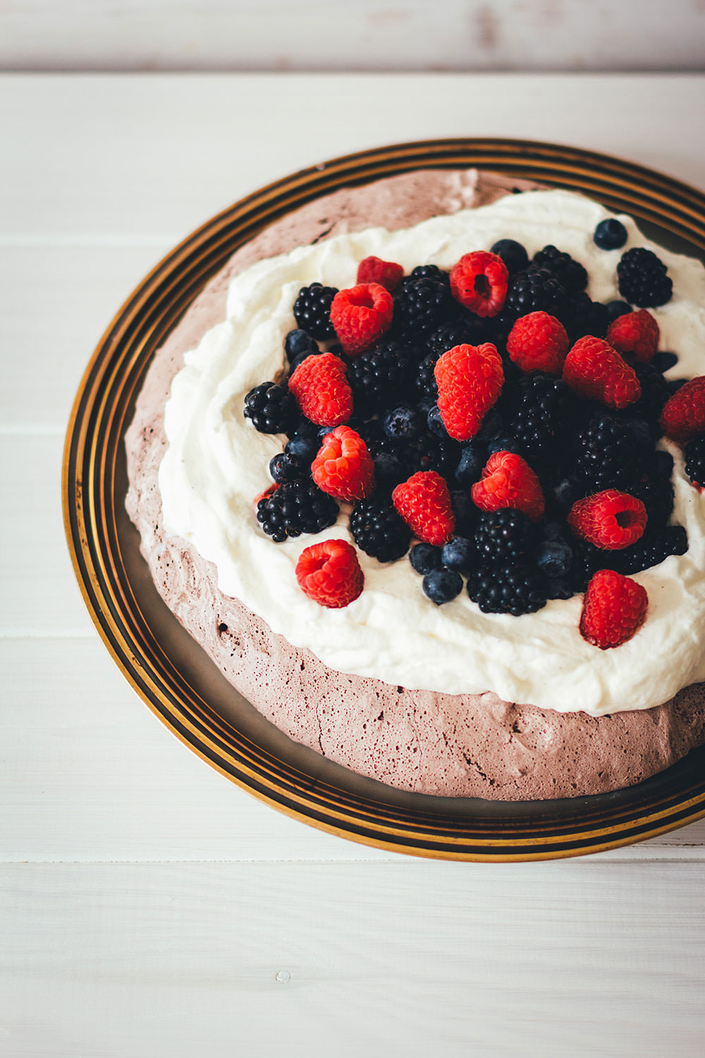 Rezept für Schoko-Pavlova mit Sommerbeeren | cremige Pavlova aus Baiser mit Schokolade, Sahne und bunten Beeren | moeyskitchen.com #pavlova #schokolade #schoko #baiser #meringue #beeren #sommerbeeren #sommerrezepte #foodblogger #rezepte #kuchen #backen #kuchenbacken