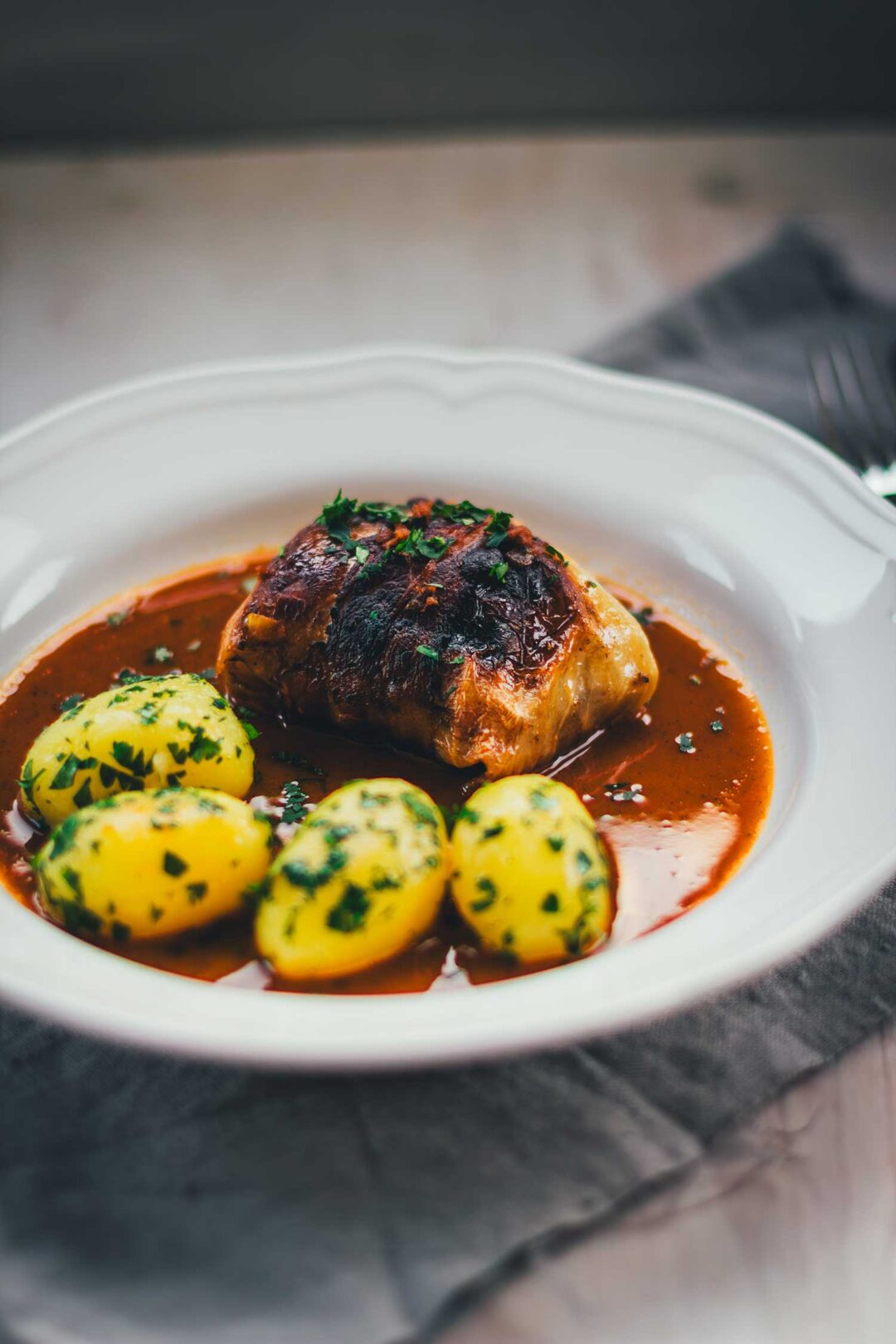Klassische Kohlrouladen mit Fleischfüllung in Sauce und Petersilienkartoffeln