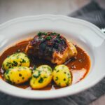 Klassische Kohlrouladen mit Fleischfüllung in Sauce und Petersilienkartoffeln
