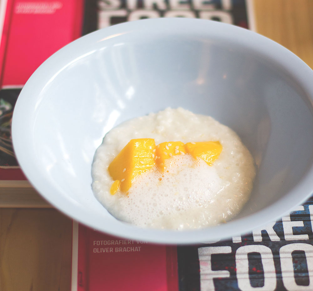 Thailändischer Klebreis (Sticky Rice) mit frischer Thai-Mango und salziger Kokosnuss von der Strassenküche im Laden Ein Thailändischer Klebreis (Sticky Rice) mit frischer Thai-Mango und salziger Kokosnuss von der Strassenküche im Laden Ein