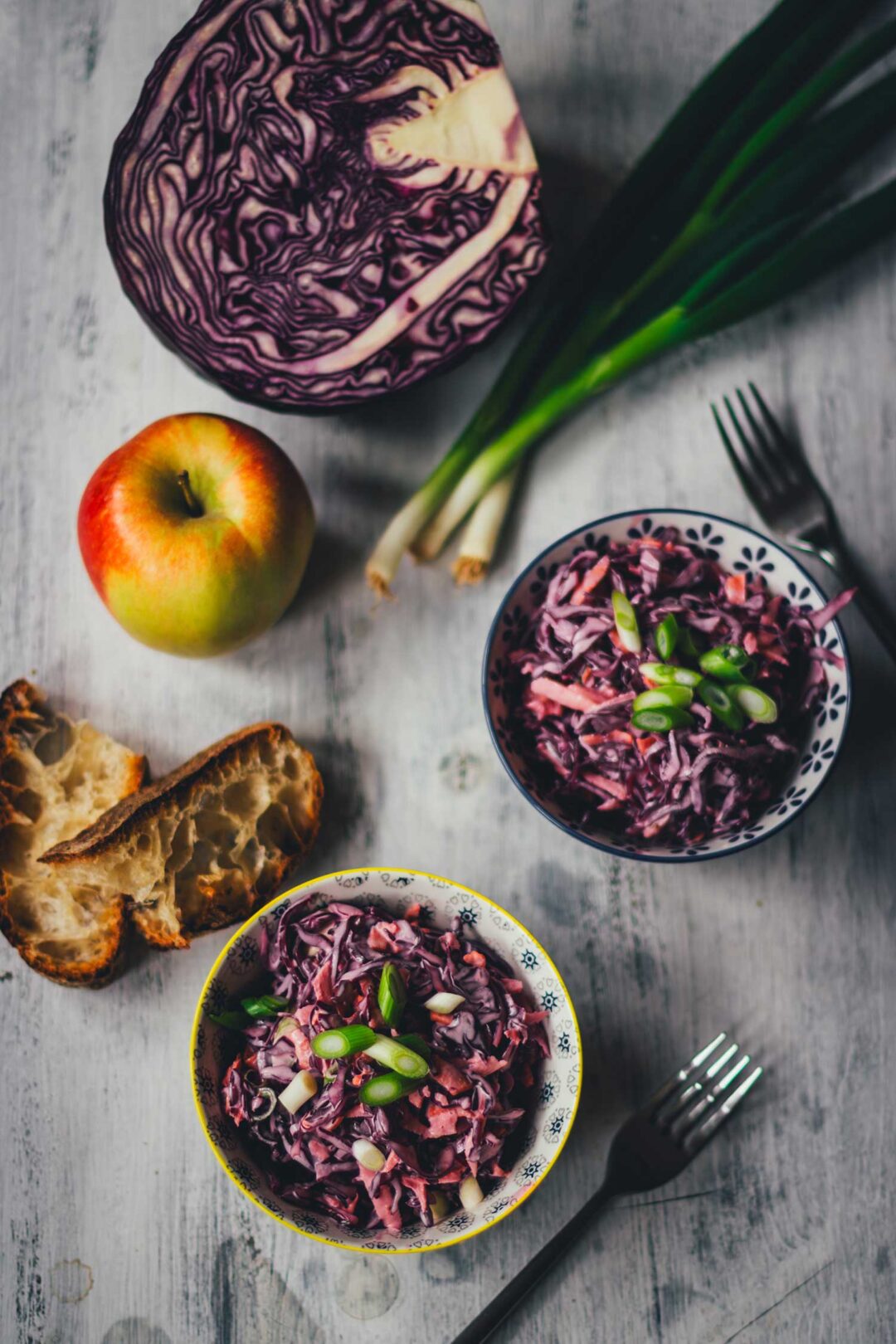 Cremiger Rotkohl Cole Slaw mit Apfel und Frühlingszwiebeln in Schüsseln serviert