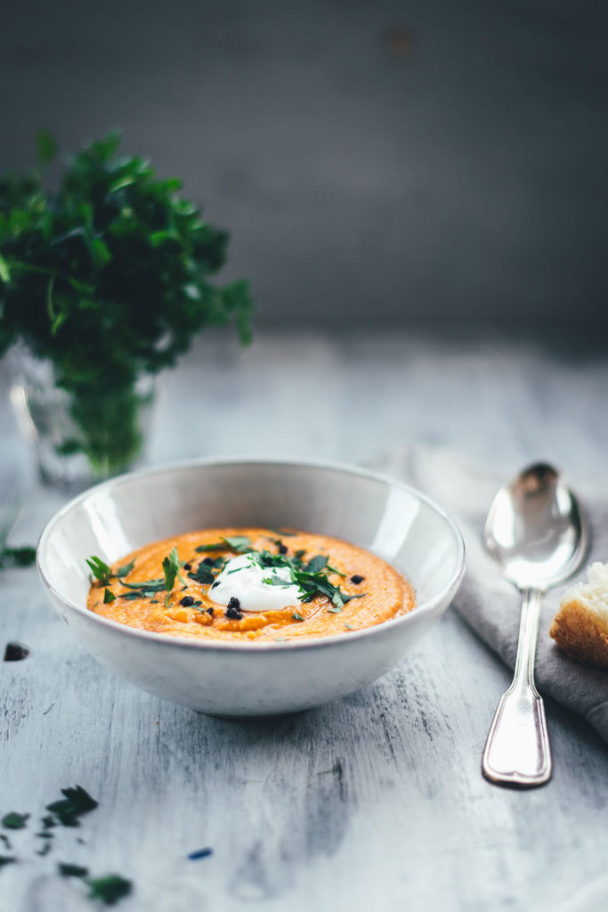 Rezept für eine würzige Rote-Linsen-Suppe mit Cayenne-Pfeffer und geräuchertem Paprikapulver. Rote Linsen und weiße Bohnen sättigen wunderbar, Möhren und Zwiebel geben der Suppe Substanz. Fein püriert und serviert mit einem Klecks Schmand und gehackter Petersilie ist es eine fantastische vegetarische Suppe für kalte Tage nicht nur im Winter! | moeyskitchen.com