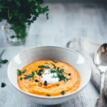 Rezept für eine würzige Rote-Linsen-Suppe mit Cayenne-Pfeffer und geräuchertem Paprikapulver. Rote Linsen und weiße Bohnen sättigen wunderbar, Möhren und Zwiebel geben der Suppe Substanz. Fein püriert und serviert mit einem Klecks Schmand und gehackter Petersilie ist es eine fantastische vegetarische Suppe für kalte Tage nicht nur im Winter! | moeyskitchen.com