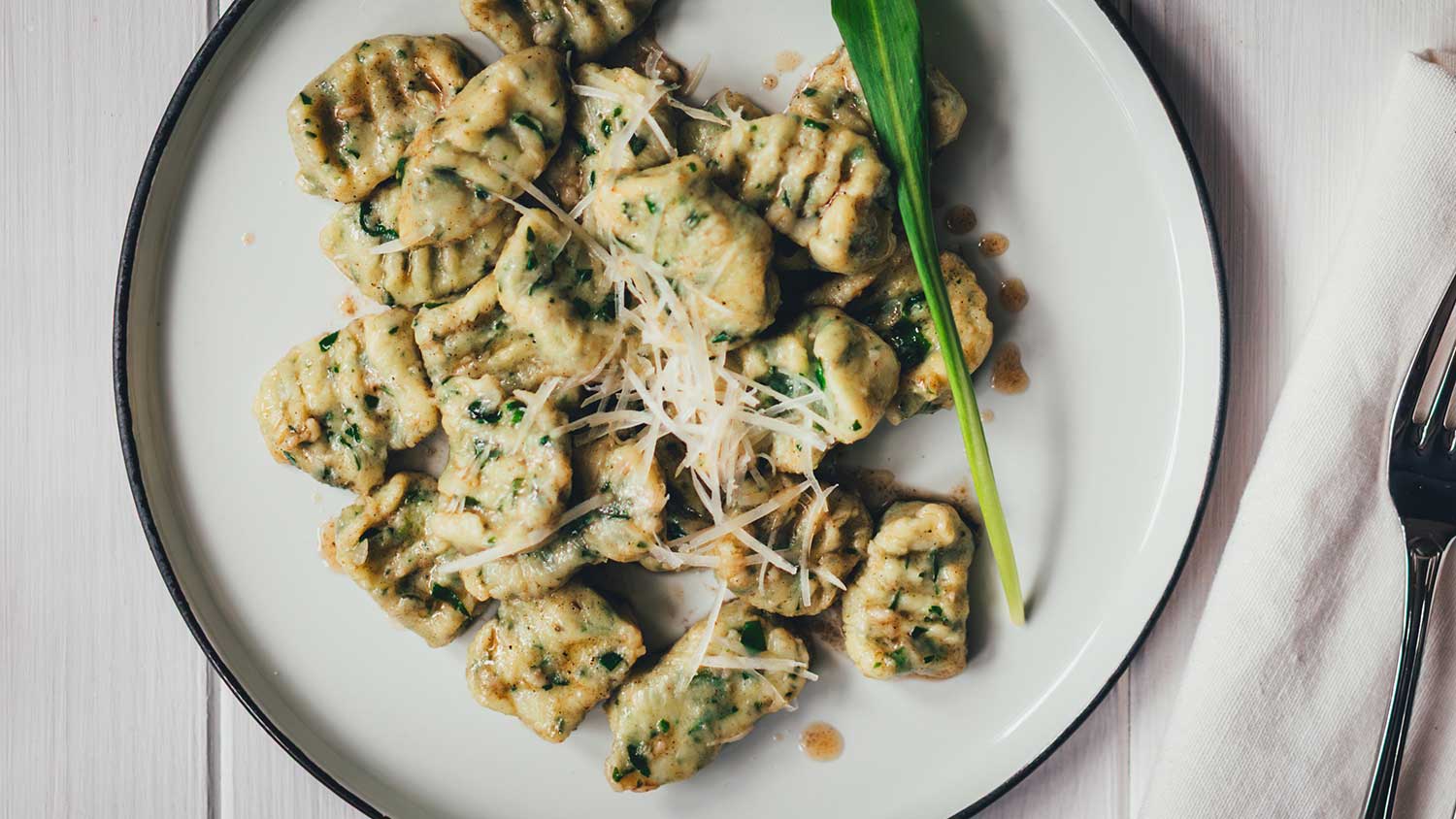 Nahaufnahme Ansicht von einem Teller mit frischen Bärlauch-Ricotta-Gnocchi mit brauner Butter.