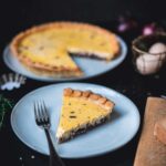 Stück Zwiebelquiche auf Teller im Fokus, im Hintergrund unscharf die restliche Quiche auf Teller sichtbar | moeyskitchen.com