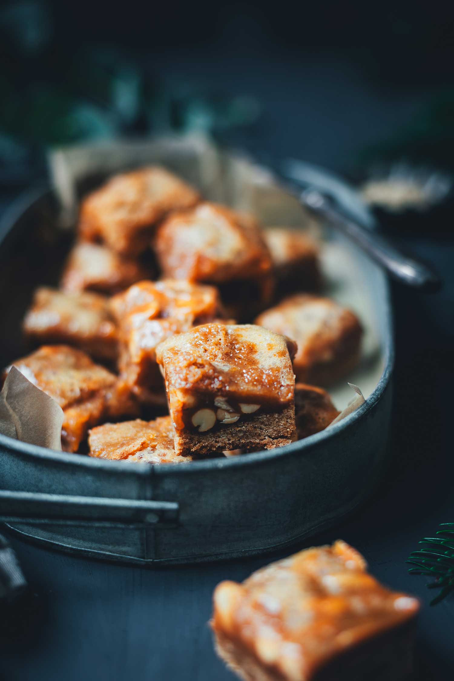 Detailaufnahme eines Lebkuchen-Karamell-Würfels mit Erdnüssen, Fokus auf der saftigen Karamelloberfläche und dem Lebkuchenboden.