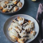 Servierfertiger Radicchio Caesar Chicken Salad auf einem Teller mit Parmesanspänen und Dressing.