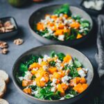 Kürbis-Salat auf zwei tiefen Tellern angerichtet – goldbraun gerösteter Butternut-Kürbis auf Rucola, garniert mit Walnusskernen und Feta, serviert mit knusprigem Brot | moeyskitchen.com