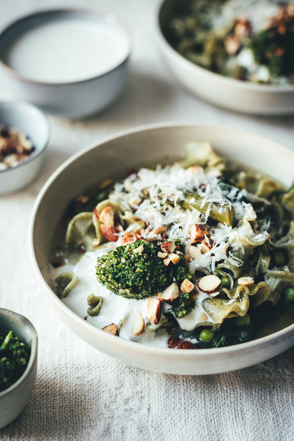 Rezept für grüne Frühsommer-Minestrone mit Pasta, grünem Spargel, Spinat, Erbsen und Parmesan | perfekt für die schnelle Feierabendküche oder Alltagsküche | Aus 1 mach 2: Mit Petersilien-Pesto, aufgeschlagenem Zitronen-Ricotta und Rauchmandeln wird die Minestrone gepimpt und eignet sich so perfekt für Gäste oder fürs Sonntagsessen | moeyskitchen.com (Werbung) #minestrone #suppe #pasta #frühling #frühsommer #rezepte #foodblogger #vegetarisch #nudelmachterfinderisch #birkel #nudelinspiration