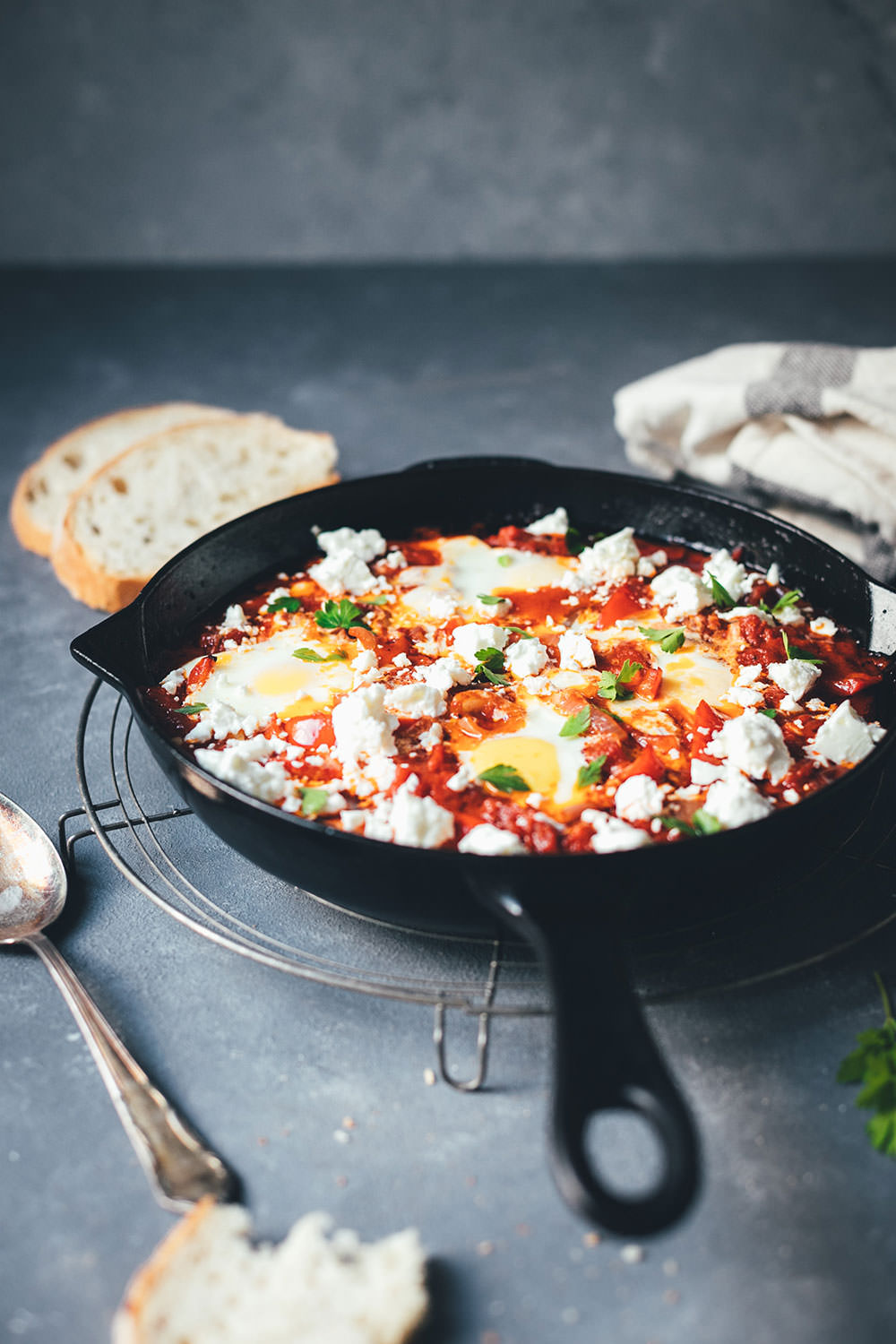 Pfanne mit Shakshuka, Eiern und Feta in der seitlichen Ansicht, fertig zum Servieren | moeyskitchen.com