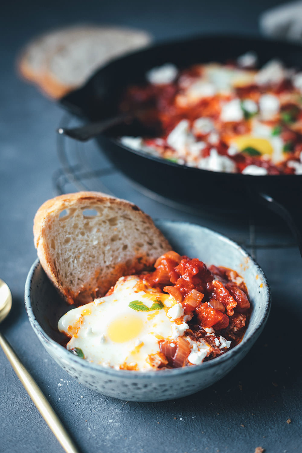 Eine Portion Shakshuka aus dem Ofen mit Ei und knusprigem Brot in einer Schüssel serviert | moeyskitchen.com