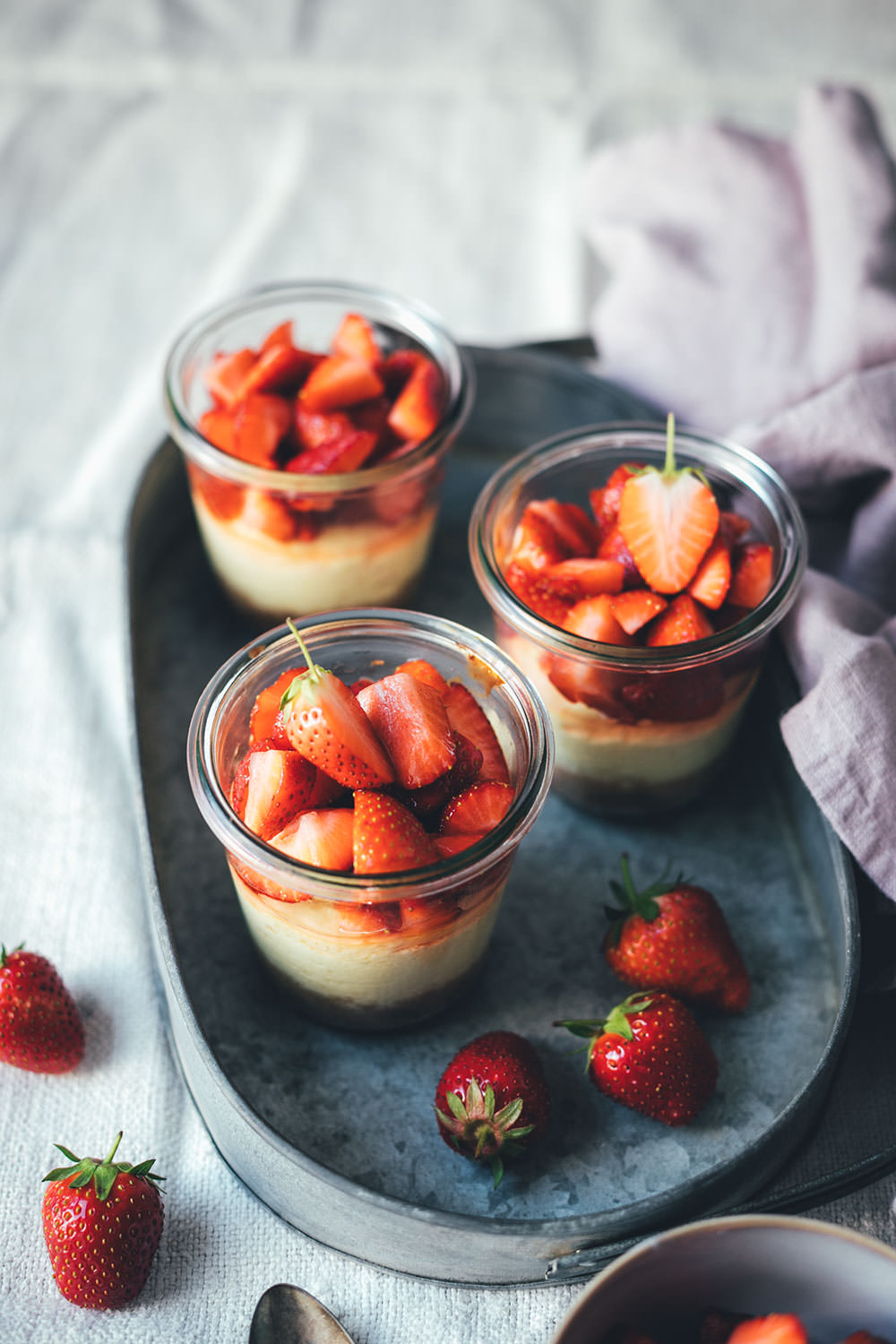 Rezept für kleine Erdbeer-Cheesecakes im Glas | individueller Cheesecake im Glas gebacken und mit frischen Erdbeeren serviert | moeyskitchen.com #cheesecake #erdbeeren #rezepte #foodblogger #käsekuchen #strawberrycheesecake #kuchen #kuchenbacken #beeren