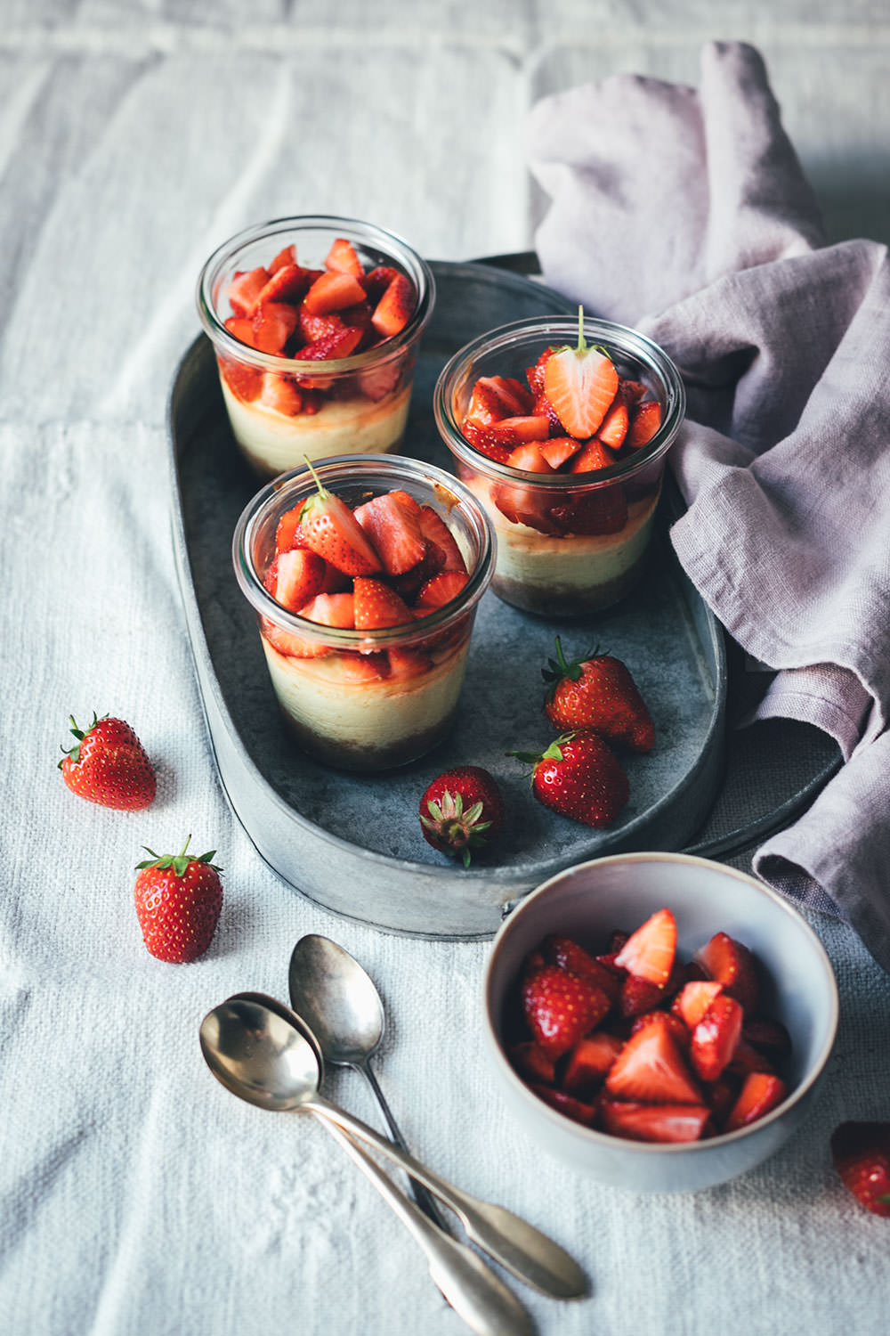 Rezept für kleine Erdbeer-Cheesecakes im Glas | individueller Cheesecake im Glas gebacken und mit frischen Erdbeeren serviert | moeyskitchen.com #cheesecake #erdbeeren #rezepte #foodblogger #käsekuchen #strawberrycheesecake #kuchen #kuchenbacken #beeren