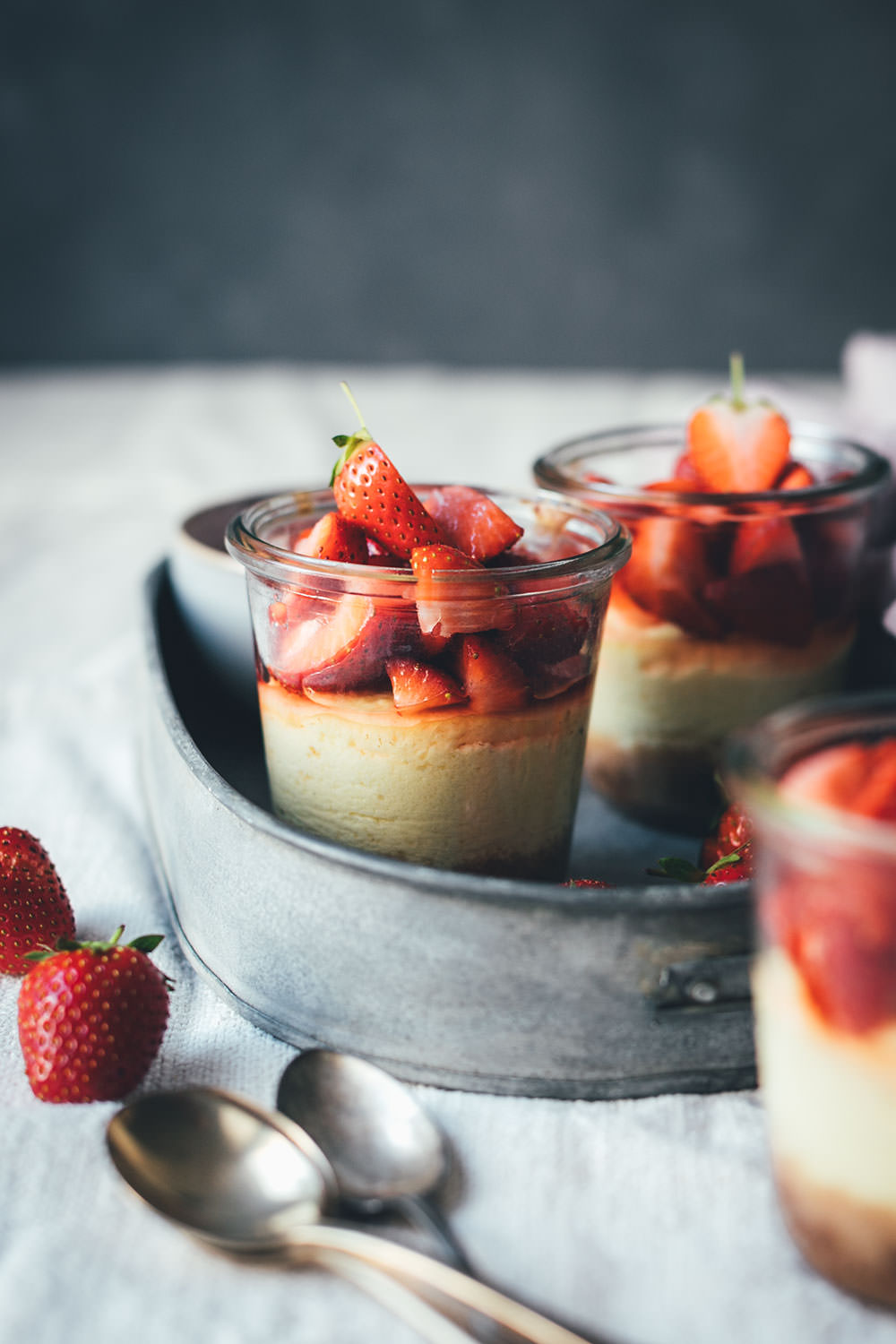 Rezept für kleine Erdbeer-Cheesecakes im Glas | individueller Cheesecake im Glas gebacken und mit frischen Erdbeeren serviert | moeyskitchen.com #cheesecake #erdbeeren #rezepte #foodblogger #käsekuchen #strawberrycheesecake #kuchen #kuchenbacken #beeren
