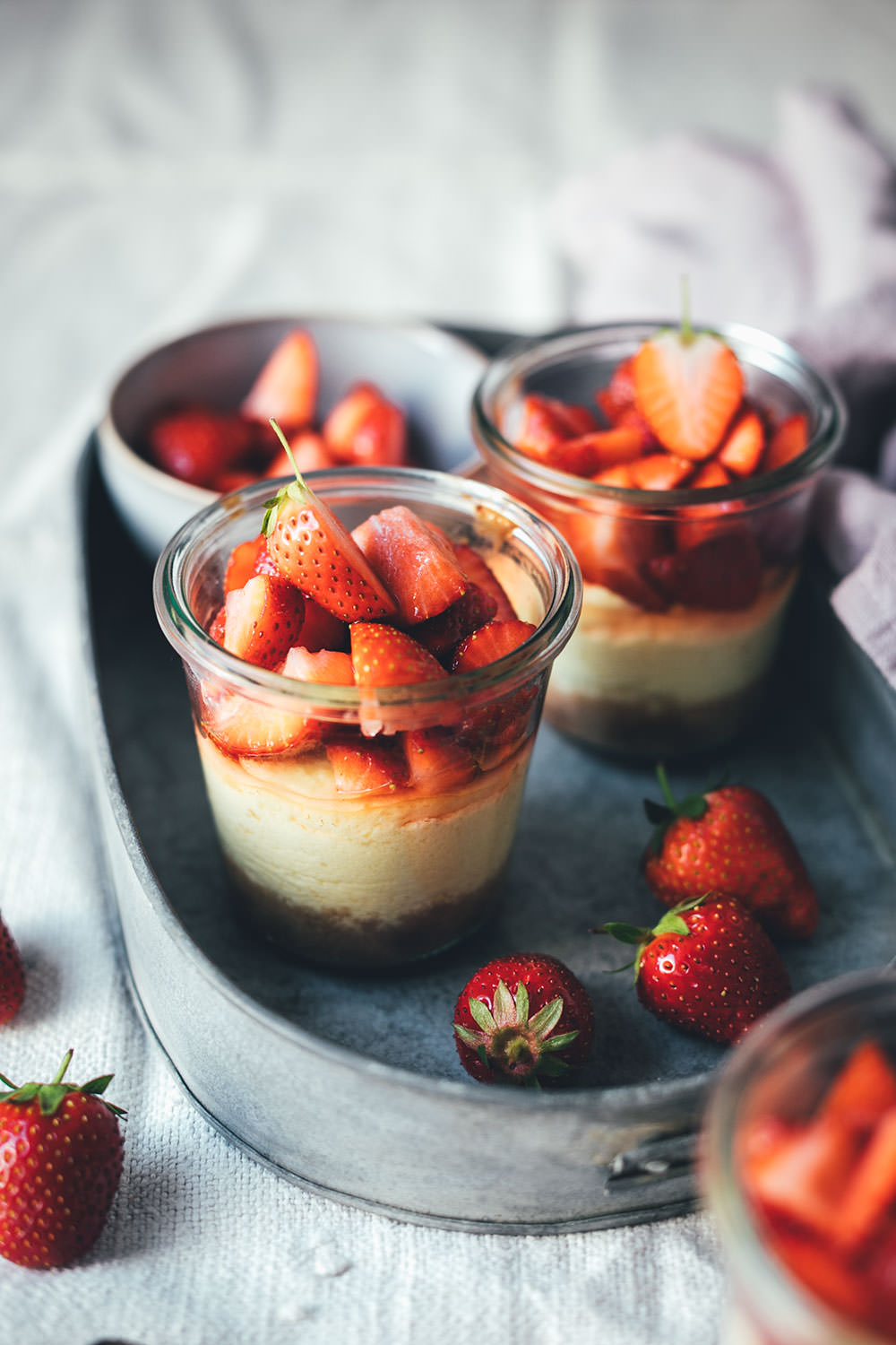 Rezept für kleine Erdbeer-Cheesecakes im Glas | individueller Cheesecake im Glas gebacken und mit frischen Erdbeeren serviert | moeyskitchen.com #cheesecake #erdbeeren #rezepte #foodblogger #käsekuchen #strawberrycheesecake #kuchen #kuchenbacken #beeren