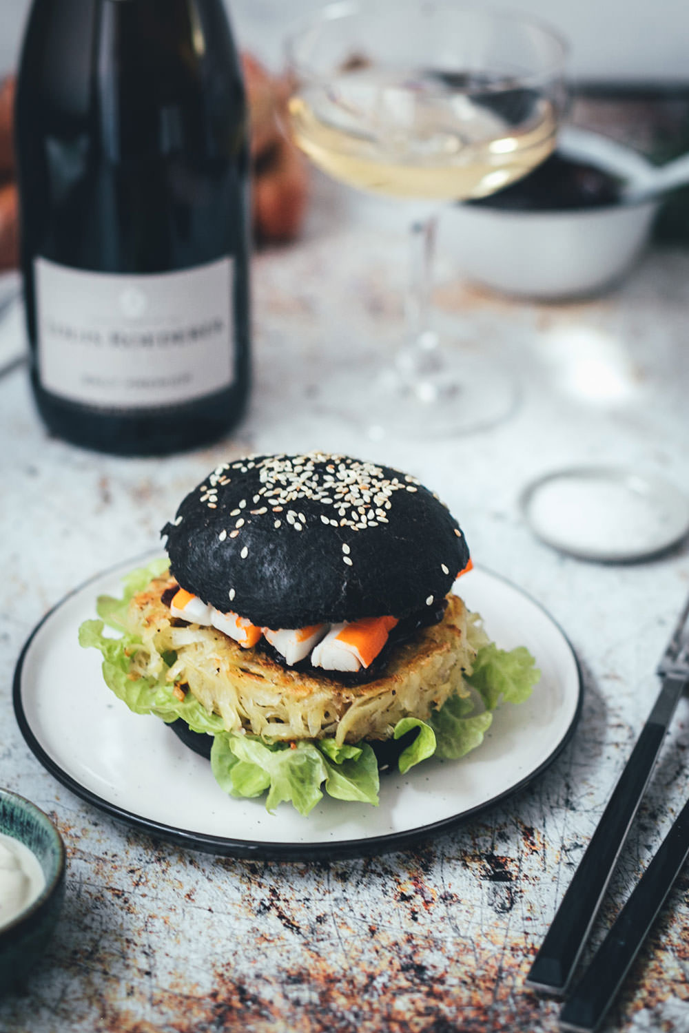 Rezept für französischen Rösti-Burger im schwarzen Brioche Burger Bun | knusprige Kartoffelrösti als Burger Patties, serviert mit Schalotten-Marmelade, Surimi-Sticks und Champagner | moeyskitchen.com #burger #hamburger #deluxeburger #rösti #kartoffelrösti #surimi #surimisticks #champagner #schalottenmarmelade