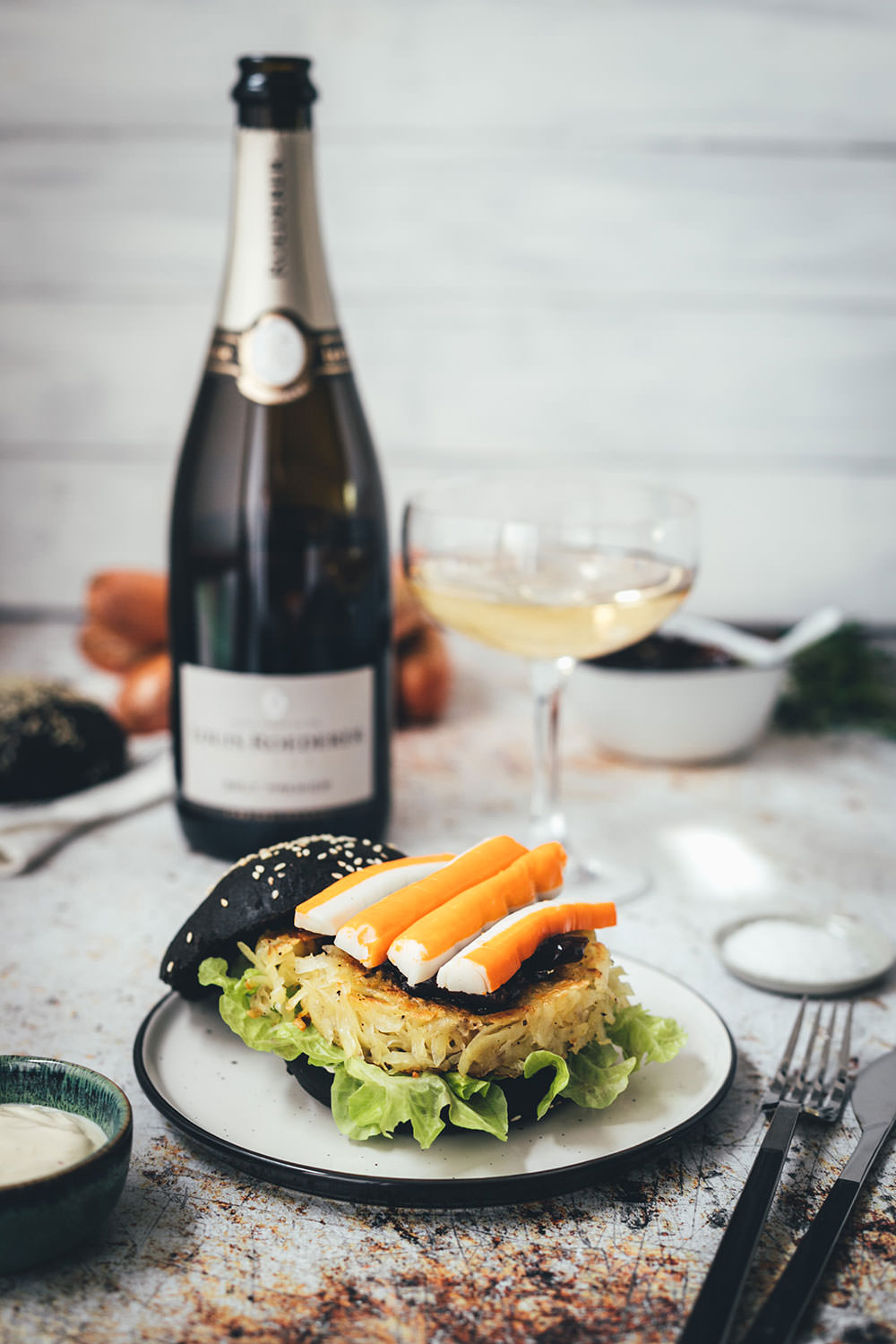 Rezept für französischen Rösti-Burger im schwarzen Brioche Burger Bun | knusprige Kartoffelrösti als Burger Patties, serviert mit Schalotten-Marmelade, Surimi-Sticks und Champagner | moeyskitchen.com #burger #hamburger #deluxeburger #rösti #kartoffelrösti #surimi #surimisticks #champagner #schalottenmarmelade