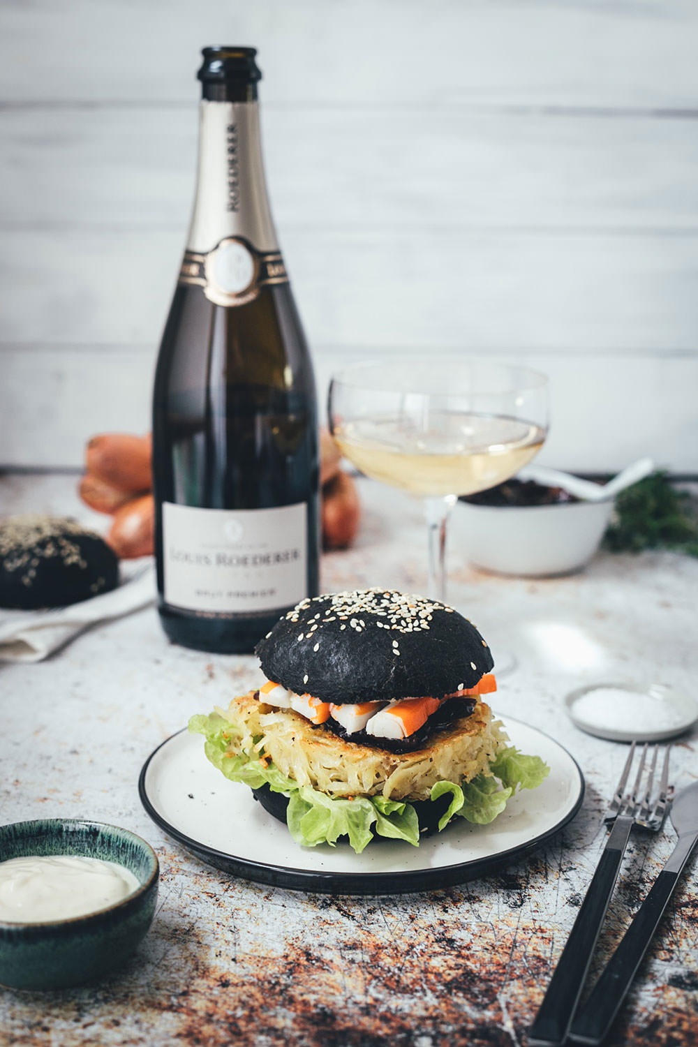 Rezept für französischen Rösti-Burger im schwarzen Brioche Burger Bun | knusprige Kartoffelrösti als Burger Patties, serviert mit Schalotten-Marmelade, Surimi-Sticks und Champagner | moeyskitchen.com #burger #hamburger #deluxeburger #rösti #kartoffelrösti #surimi #surimisticks #champagner #schalottenmarmelade