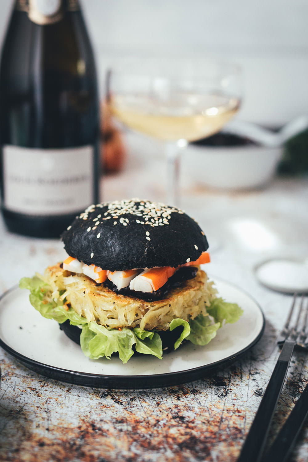 Rezept für französischen Rösti-Burger im schwarzen Brioche Burger Bun | knusprige Kartoffelrösti als Burger Patties, serviert mit Schalotten-Marmelade, Surimi-Sticks und Champagner | moeyskitchen.com #burger #hamburger #deluxeburger #rösti #kartoffelrösti #surimi #surimisticks #champagner #schalottenmarmelade