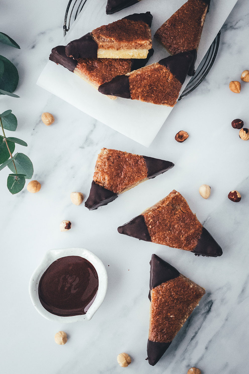 Hier habe ich das Rezept für super einfache und so saftige Nussecken. Ein einfacher Mürbeteig wird mit Aprikosenkonfitüre und einer saftigen Nussmasse mit Haselnüssen belegt und gebacken. Die Zubereitung ist kinderleicht und die Nussecken sind super schnell im Ofen. Sie schmecken das ganze Jahr über zu jeder Gelegenheit, passen aber auch hervorragend zu Weihnachten und in die Adventszeit, dank reichlich Nüssen und Schokolade | moeyskitchen.com