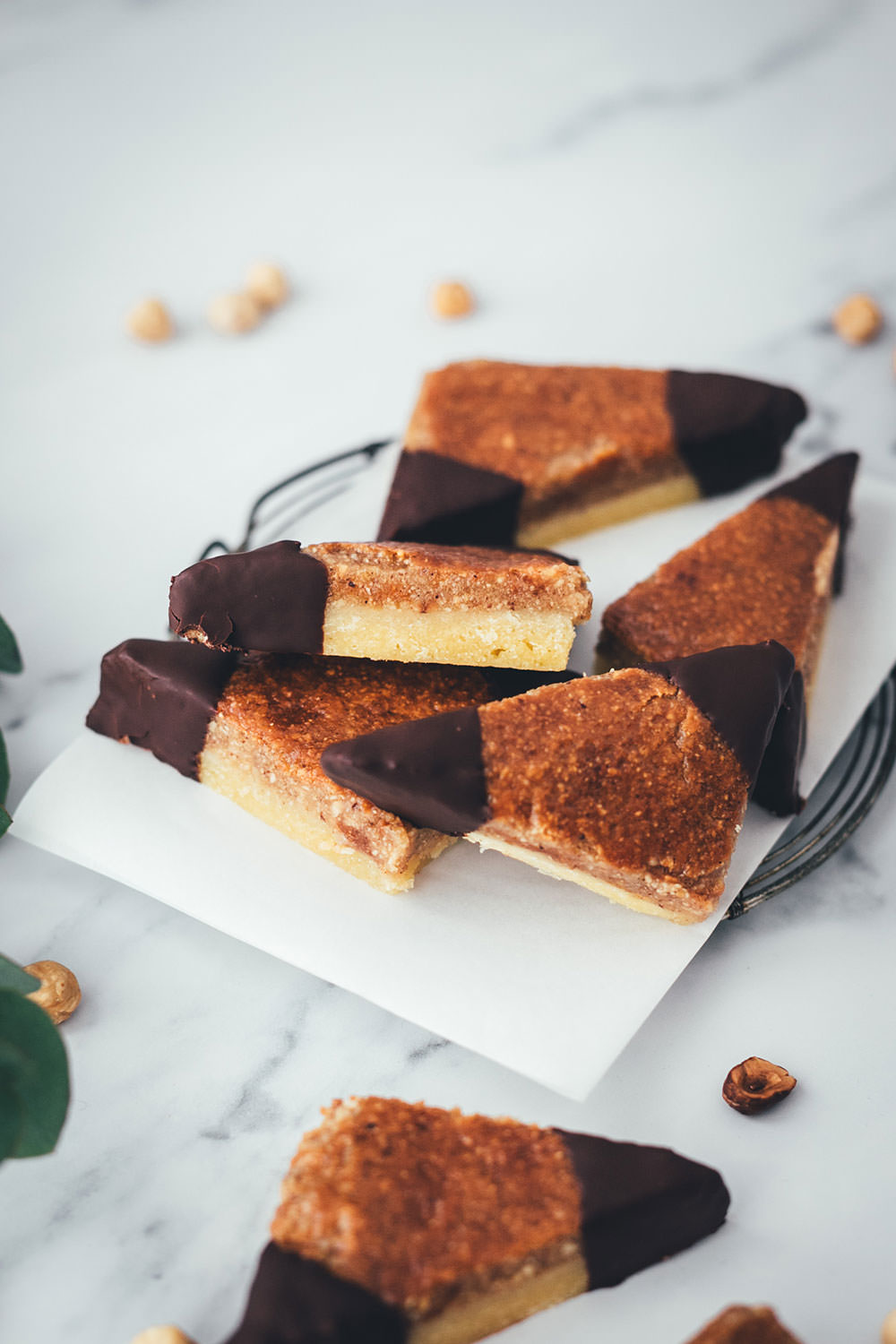Hier habe ich das Rezept für super einfache und so saftige Nussecken. Ein einfacher Mürbeteig wird mit Aprikosenkonfitüre und einer saftigen Nussmasse mit Haselnüssen belegt und gebacken. Die Zubereitung ist kinderleicht und die Nussecken sind super schnell im Ofen. Sie schmecken das ganze Jahr über zu jeder Gelegenheit, passen aber auch hervorragend zu Weihnachten und in die Adventszeit, dank reichlich Nüssen und Schokolade | moeyskitchen.com
