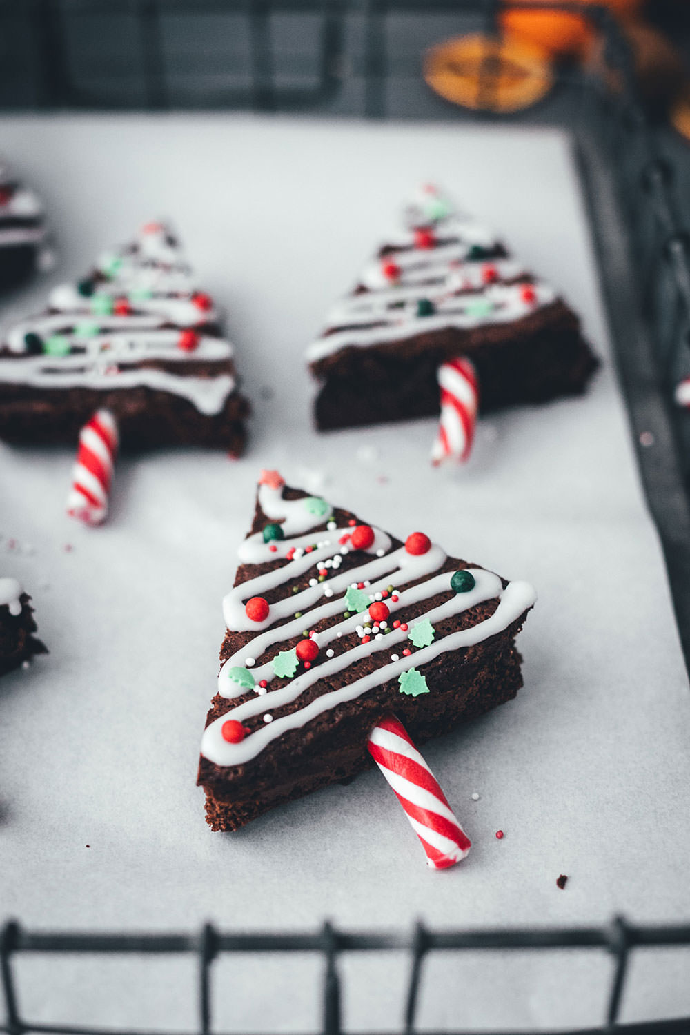 Rezept für Weihnachtsbaum-Brownies – das sind einfache Brownies in Tannenbaum-Form, die mit Zuckerstangen, Zuckerguss und bunten Perlen verziert werden. Ein Spaß für die ganze Familie und das perfekte Gebäck für die Advents- und Weihnachtszeit!