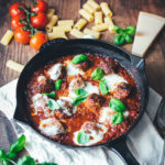 Rezept für den amerikanisch-italienischen Klassiker Baked Meatballs. Das sind saftige gratinierte Hackbällchen in Tomatensauce, die mit Mozzarella überbacken werden. Hier kennt man sie auch als "Hackbällchen Toskana". Sie schmecken fantastisch zu Pasta wie Spaghetti, Rigatoni oder auch einfach mit frischem, knusprigem Brot. | moeyskitchen.com