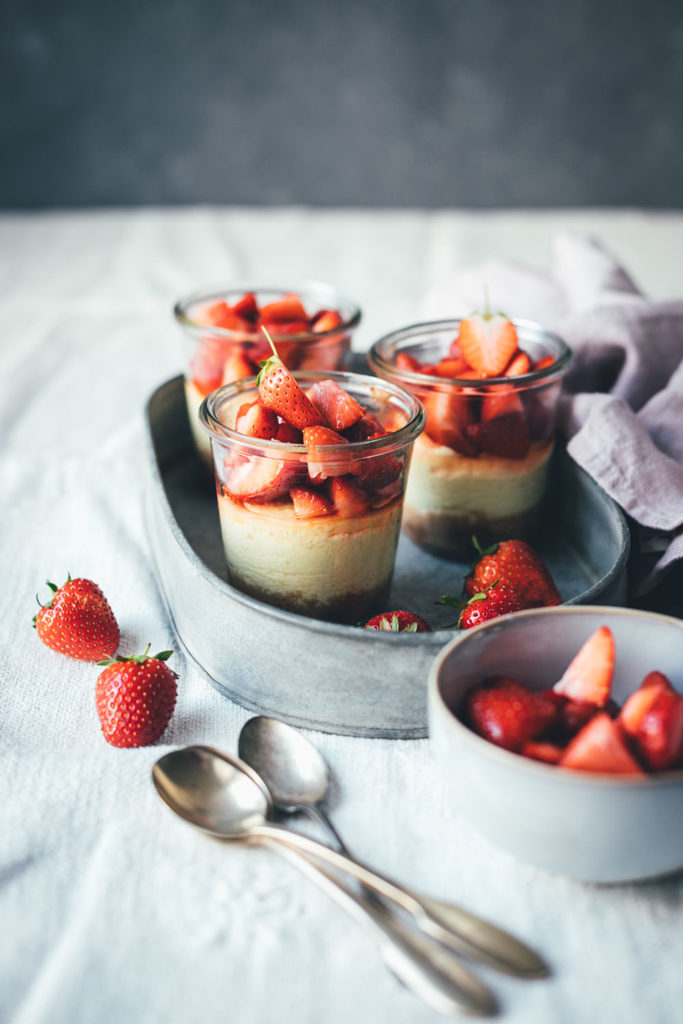 Rezept für kleine Erdbeer-Cheesecakes im Glas | individueller Cheesecake im Glas gebacken und mit frischen Erdbeeren serviert | moeyskitchen.com #cheesecake #erdbeeren #rezepte #foodblogger #käsekuchen #strawberrycheesecake #kuchen #kuchenbacken #beeren