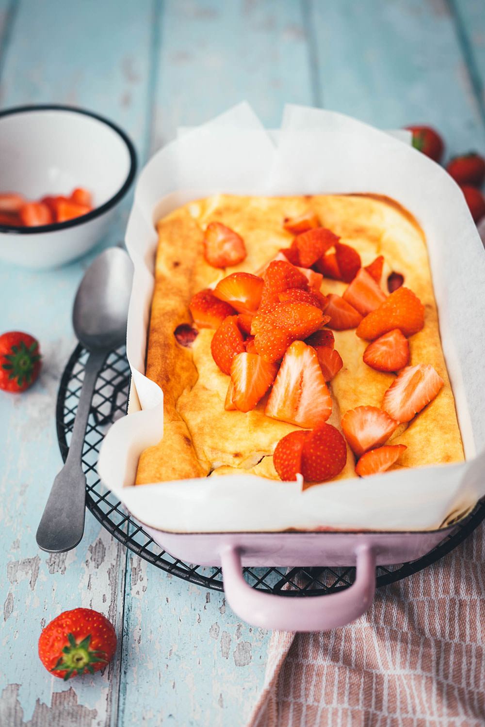 Rezept für luftigen Quark-Auflauf mit Erdbeeren. Leckeres, nicht zu süßes Dessert oder Frühstück für die ganze Familie! Magerquark wird dazu einfach mit Ei und Grieß locker aufgeschlagen und dann mit Erdbeeren in einer Auflaufform gebacken. Anschließend lauwarm mit frischen Erdbeeren serviert, so dass es an einen leckeren, aber unheimlich einfachen Käsekuchen erinnert. | moeyskitchen.com