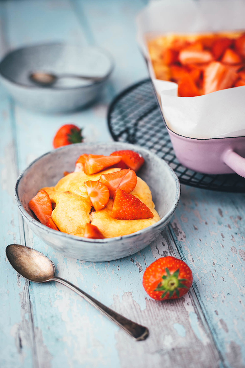 Rezept für luftigen Quark-Auflauf mit Erdbeeren. Leckeres, nicht zu süßes Dessert oder Frühstück für die ganze Familie! Magerquark wird dazu einfach mit Ei und Grieß locker aufgeschlagen und dann mit Erdbeeren in einer Auflaufform gebacken. Anschließend lauwarm mit frischen Erdbeeren serviert, so dass es an einen leckeren, aber unheimlich einfachen Käsekuchen erinnert. | moeyskitchen.com
