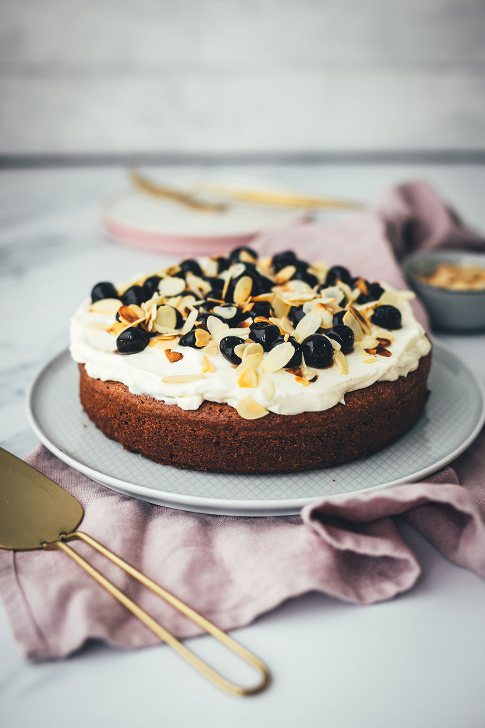 Der italienische Kuchenklassiker in neuem Gewand: Torta Caprese ist ein super saftiger Schokoladenkuchen, der ganz ohne Mehl auskommt. Stattdessen kommen hier zerkleinerte, geröstete Mandeln in den Teig. Und statt die Torta Caprese wie im Original nur mit Puderzucker zu bestreuen, serviere ich sie hier mit einer wunderbaren Mascarpone-Creme, leckeren Amarenakirschen und zusätzlich mit gerösteten Mandelblättchen. Der saftigste Schokokuchen überhaupt! | moeyskitchen.com