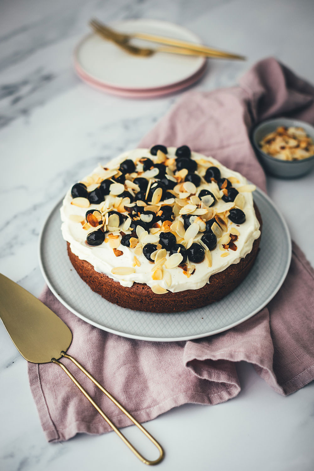 Der italienische Kuchenklassiker in neuem Gewand: Torta Caprese ist ein super saftiger Schokoladenkuchen, der ganz ohne Mehl auskommt. Stattdessen kommen hier zerkleinerte, geröstete Mandeln in den Teig. Und statt die Torta Caprese wie im Original nur mit Puderzucker zu bestreuen, serviere ich sie hier mit einer wunderbaren Mascarpone-Creme, leckeren Amarenakirschen und zusätzlich mit gerösteten Mandelblättchen. Der saftigste Schokokuchen überhaupt! | moeyskitchen.com
