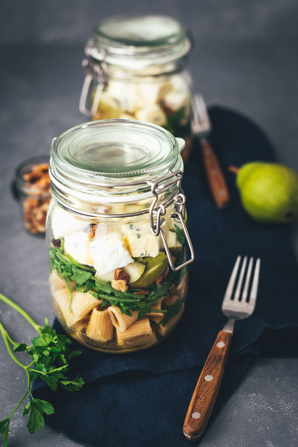 Rezept für herbstlichen Nudelsalat im Glas. Das perfekte Mittagessen für unterwegs, zum Picknick, im Büro oder am heimischen Schreibtisch. Mit kerniger Vollkorn-Pasta, knackiger Birne, würzigem Rucola, gerösteten Walnusskernen und leckerem CAMBOZOLA. Einfach zu machen und gut als Meal Prep vorzubereiten. | moeyskitchen.com