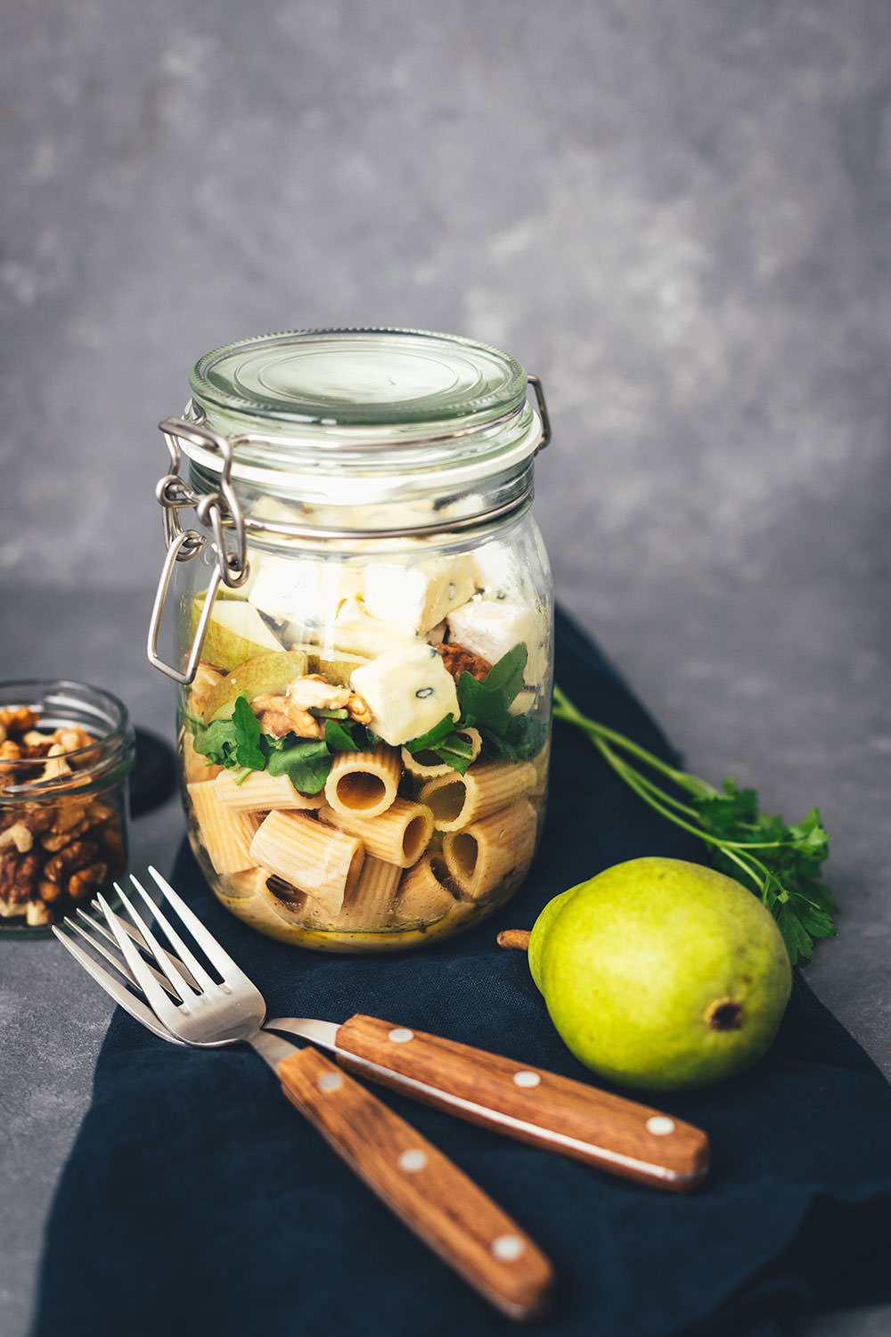 Rezept für herbstlichen Nudelsalat im Glas. Das perfekte Mittagessen für unterwegs, zum Picknick, im Büro oder am heimischen Schreibtisch. Mit kerniger Vollkorn-Pasta, knackiger Birne, würzigem Rucola, gerösteten Walnusskernen und leckerem CAMBOZOLA. Einfach zu machen und gut als Meal Prep vorzubereiten. | moeyskitchen.com