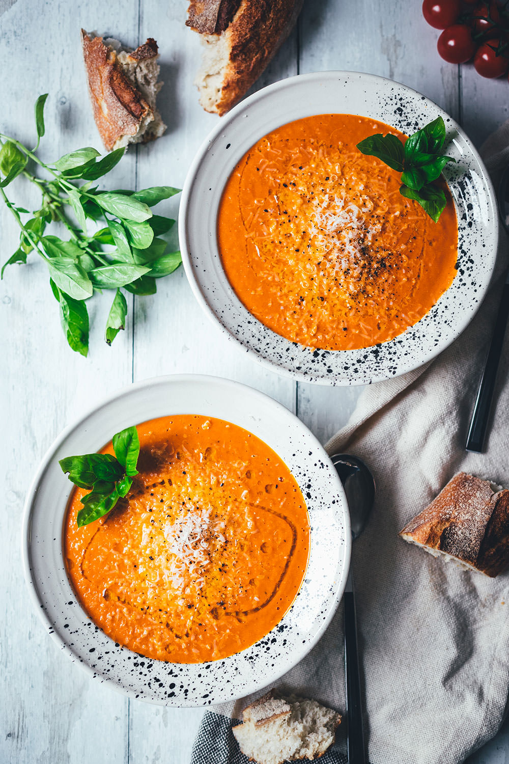 Rezept für cremige Tomatensuppe als blitzschnelle Rösttomatensuppe aus dem Ofen. Verfeinert mit Zwiebeln, Knoblauch, Parmesan und Basilikum. Fix auf dem Tisch und perfekt für die schnelle Feierabendküche im Spätsommer! | moeyskitchen.com